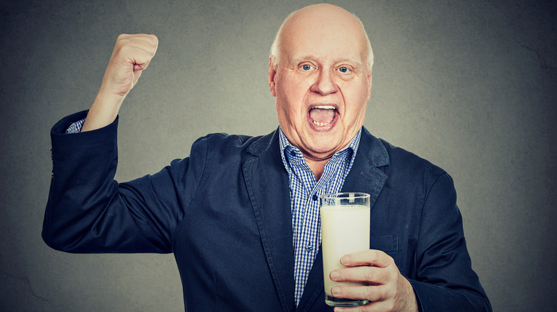 Man holding milk flexing arm