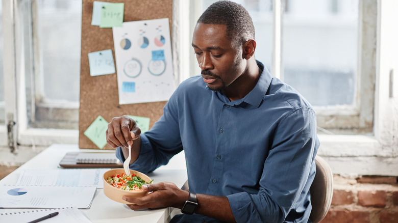 Man eating bowl of salad