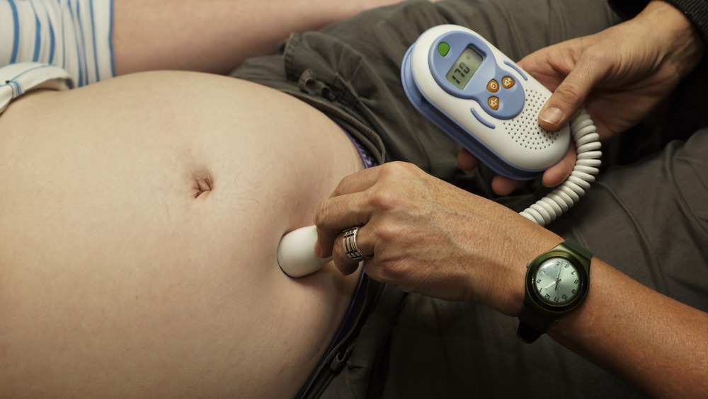 Midwife listening to fetal heartbeat