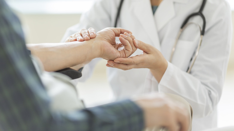 doctor looking at patient's hand