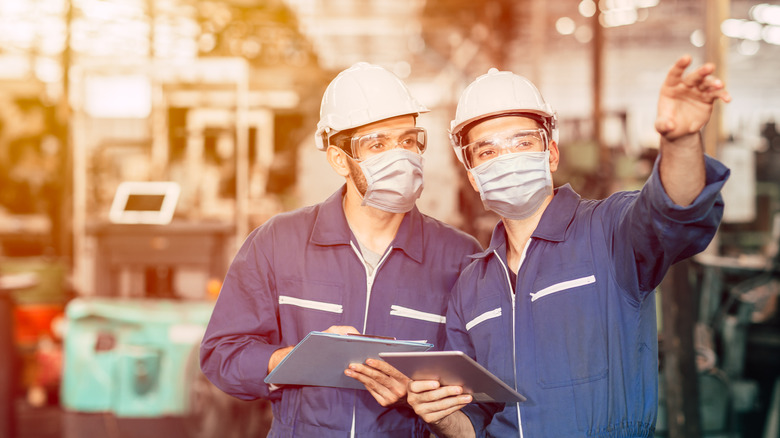 two people wearing a mask in a factory 