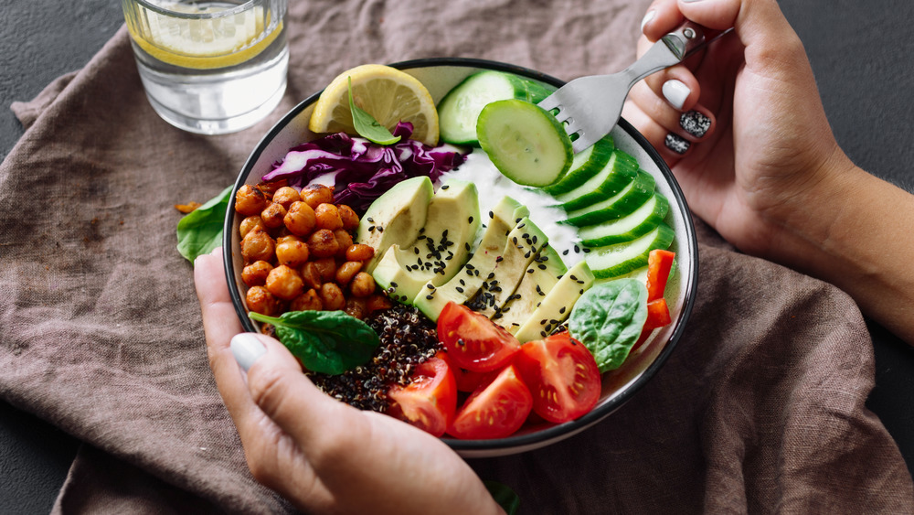 Hands holding a yummy veggie bowl