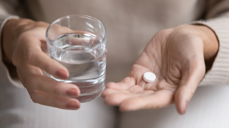 Older woman holding aspirin