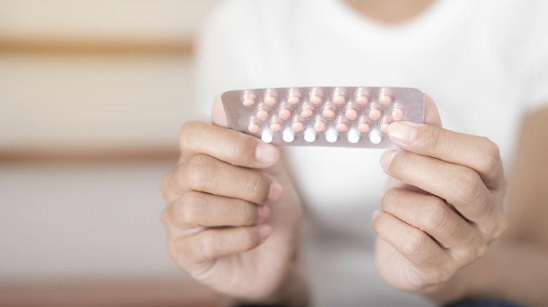 woman holding birth control pills in her hands