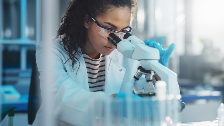 Scientist looking through microscope