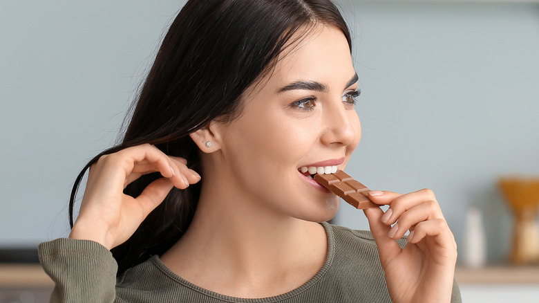 Woman eating chocolate in the kitchen