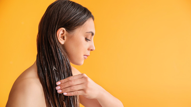 Woman putting oil in hair