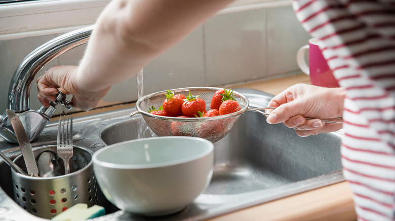 woman rinsing off berries