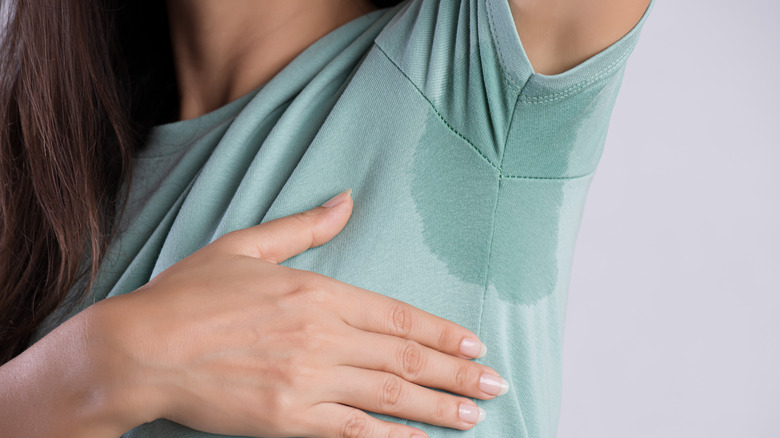 A woman sweats through her shirt