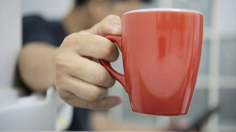 Man drinking coffee and pooping