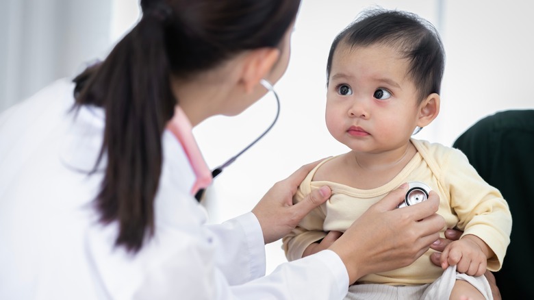 Doctor placing stethoscope on child's chest