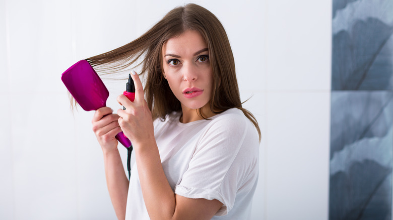 Woman spraying hair