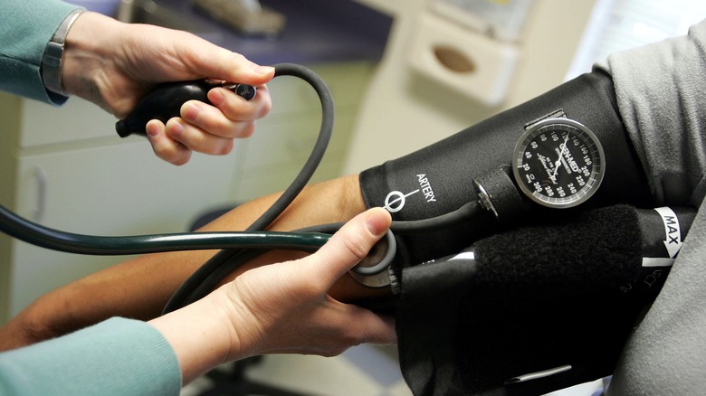 doctor checking patient's blood pressure