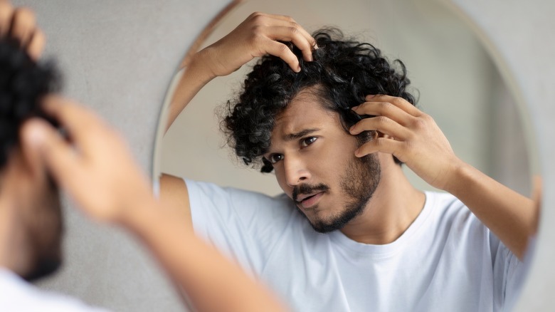 Person checking hair in mirror