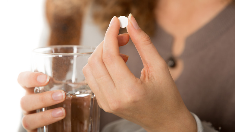 close-up of hand holding white pill