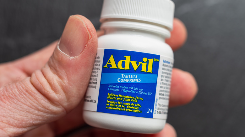 hand holding bottle of Advil tablets