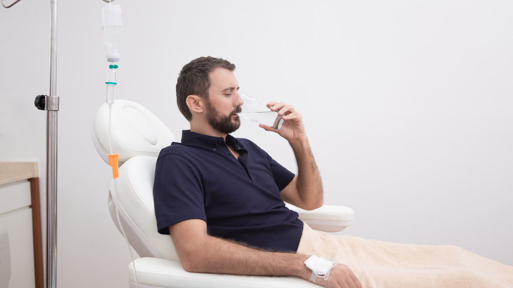 hungover man replenishing with IV vitamin therapy