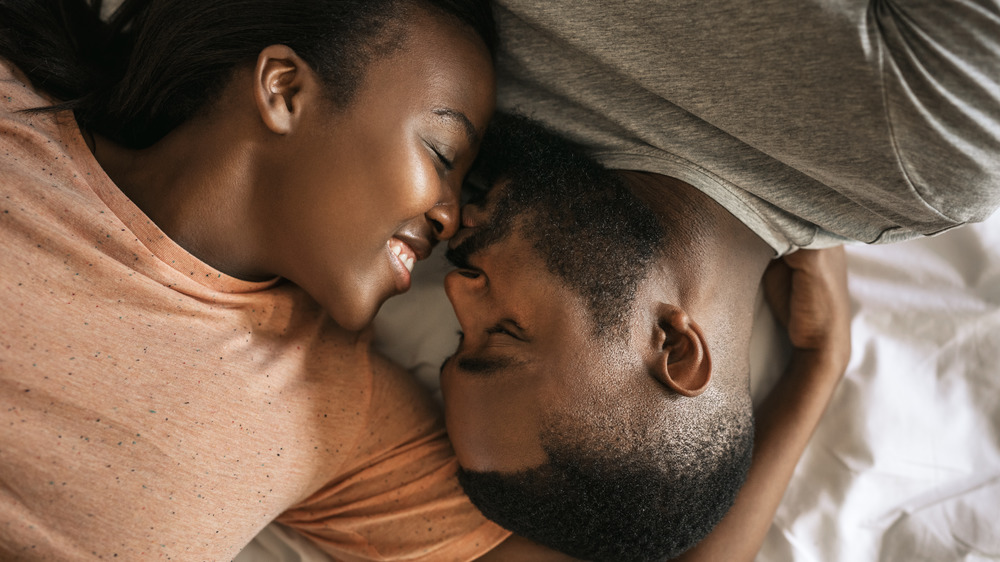 Close up of man and woman kissing in bed