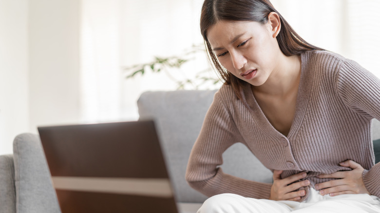 woman with lupus holding stomach