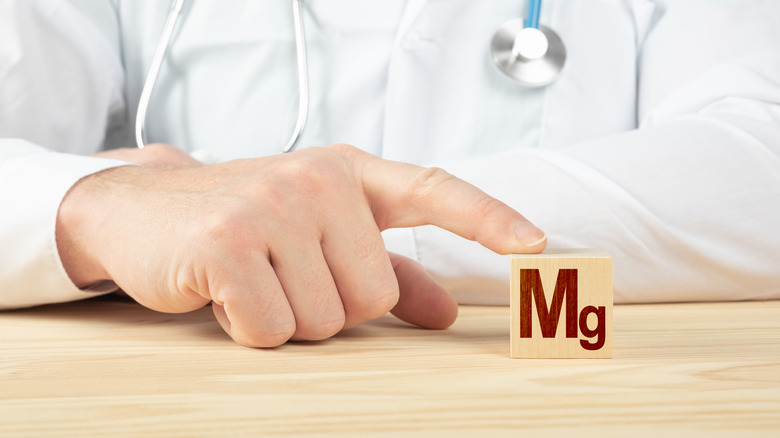 Doctor touching a building block that represents magnesium 