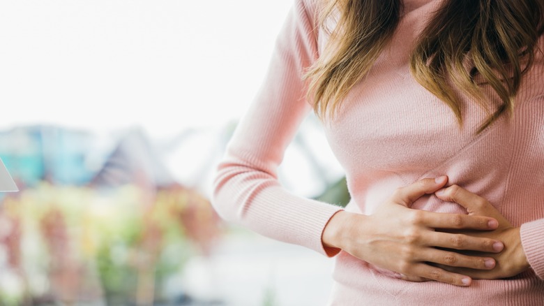 woman holding stomach in discomfort