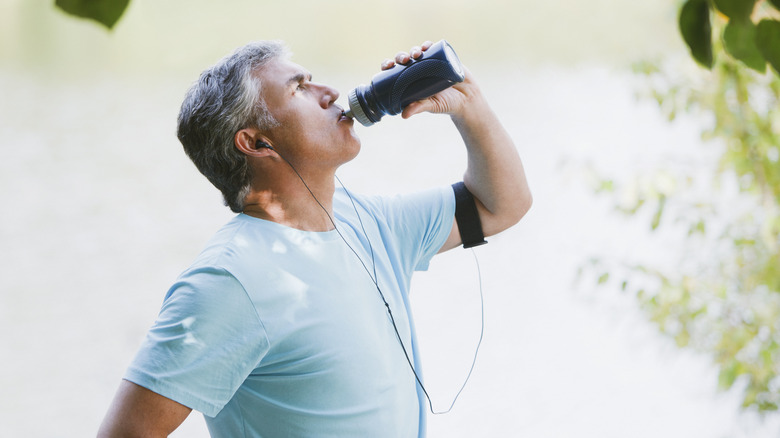 man drinking out of bottle after workout