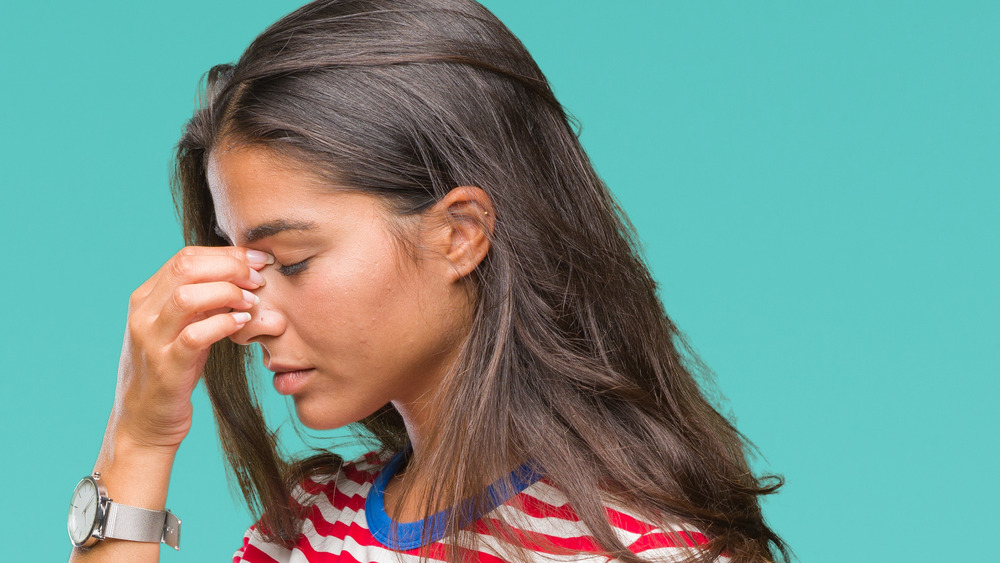 woman holding bridge of nose