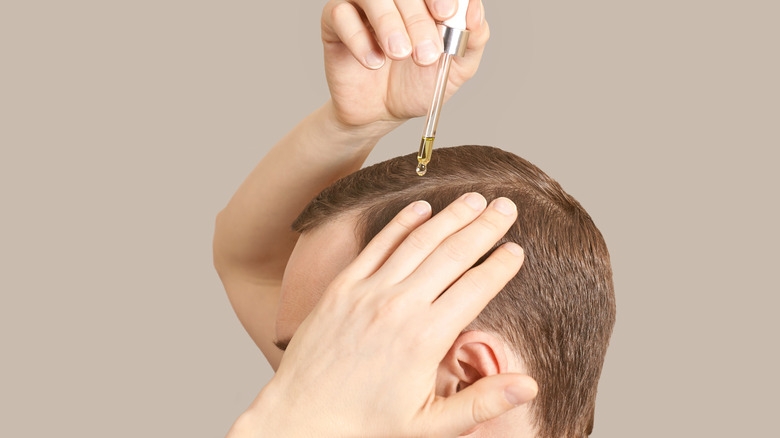 Dropper administering essential oil onto scalp