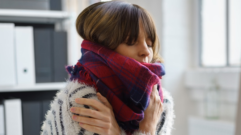 woman shivering in office
