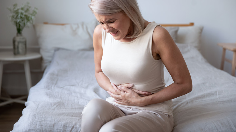 woman holding stomach in pain