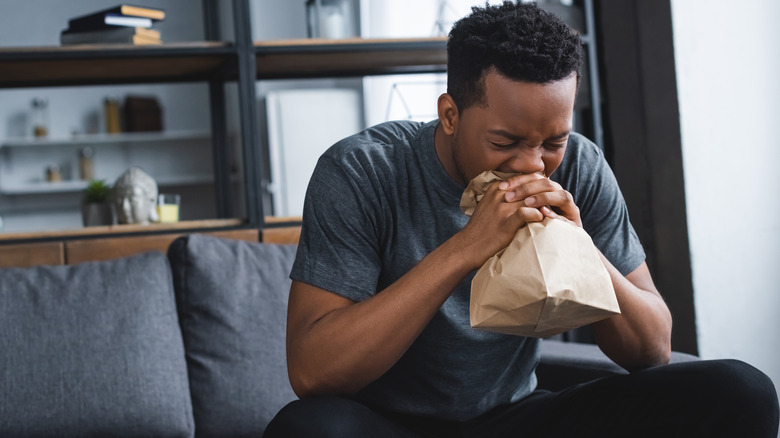 Man breathing into paper bag