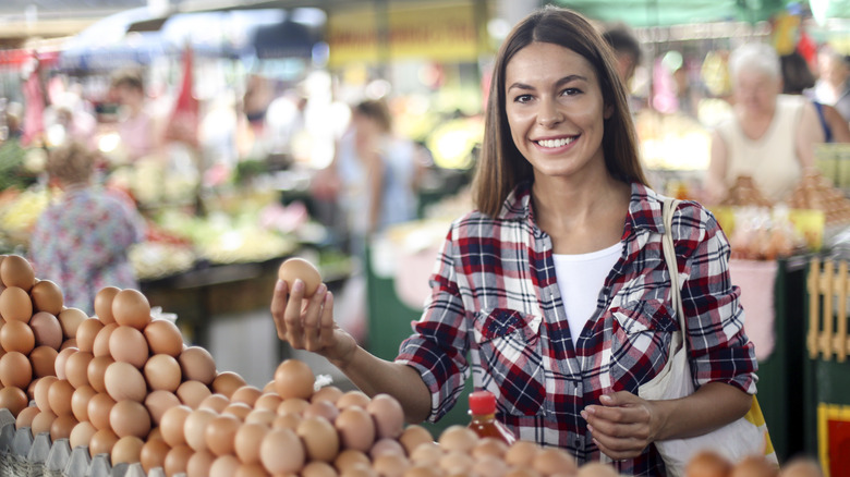 woman choosing eggs farmer's market