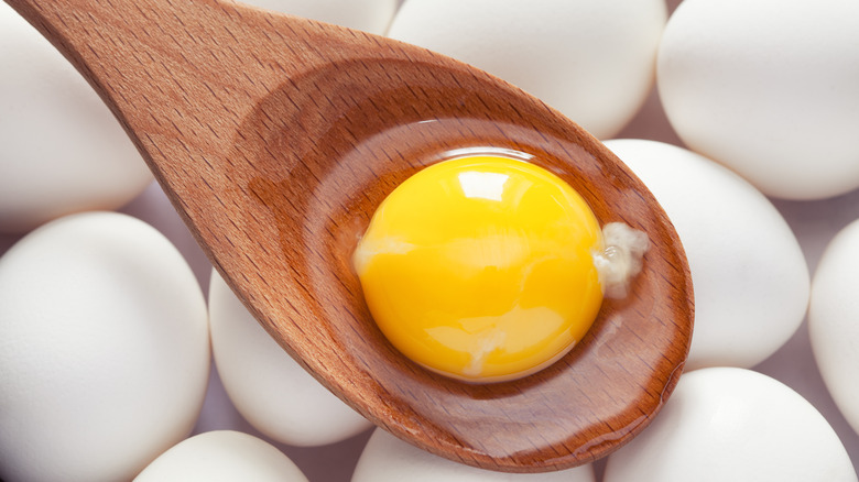 yellow egg yolk wooden spoon