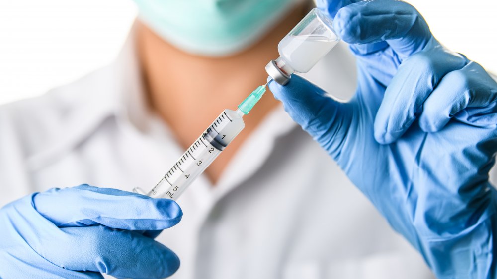 Doctor holds a syringe