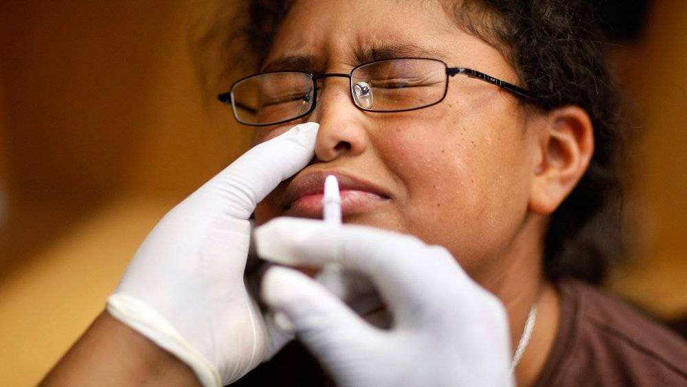 A woman receives a nasal vaccine