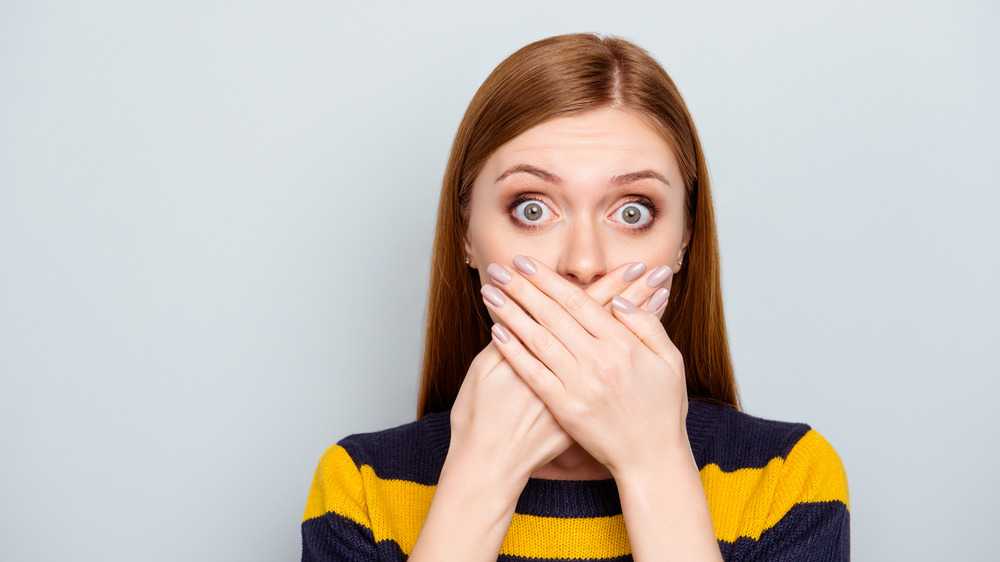 A red-headed woman worried about her breath 