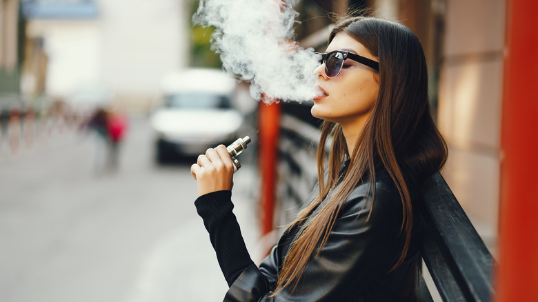 Woman smoking an e-cigarette outside