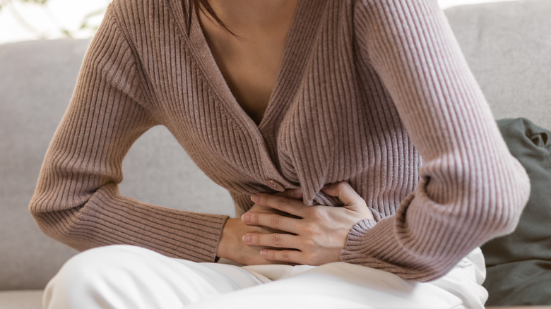 woman holding her stomach in pain