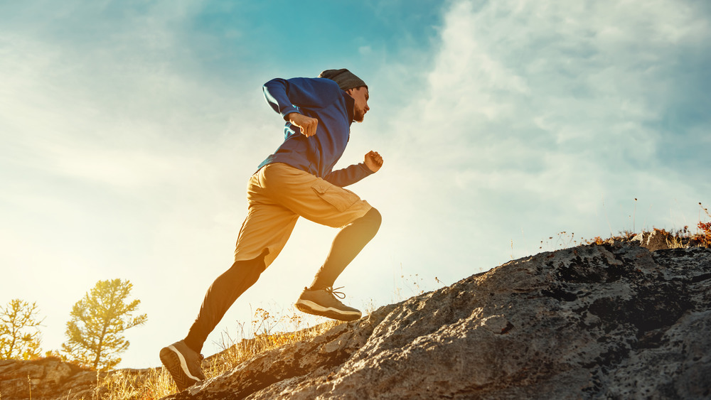 man walking up hill