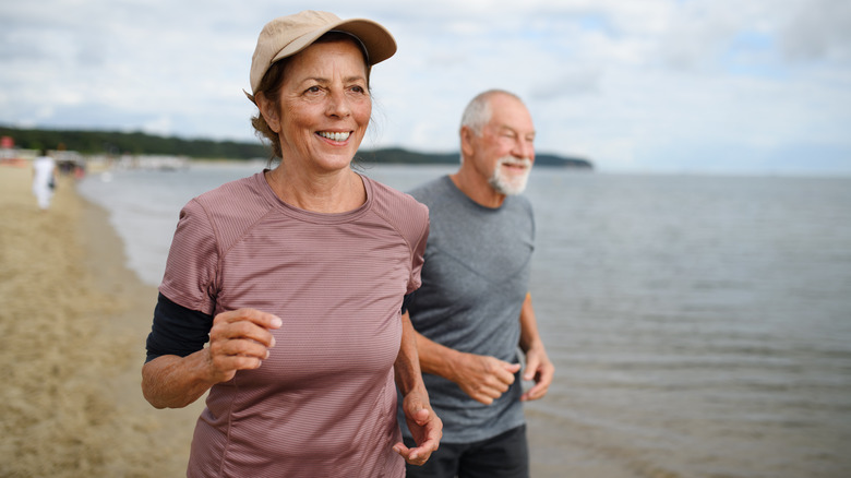 A senior couple running together outside