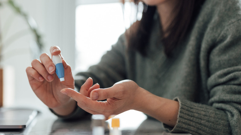 A woman administering a blood test at home