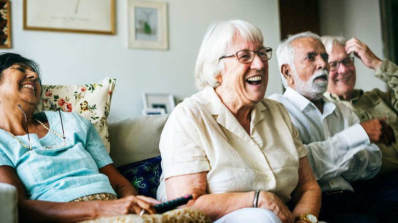 Smiling senior citizens watch something