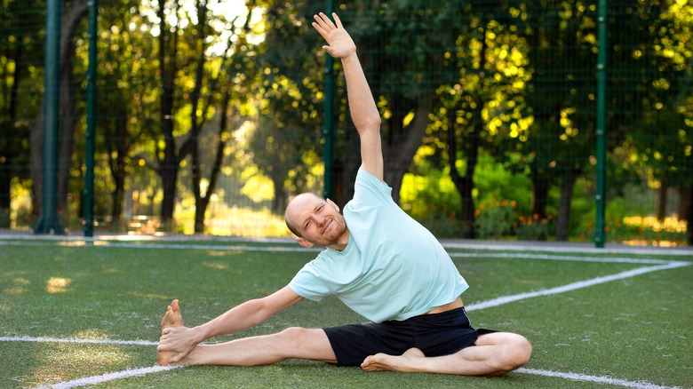 man doing a side bend yoga pose