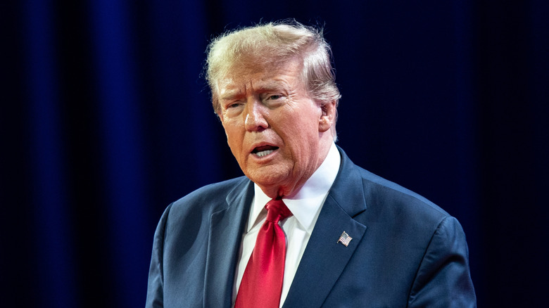 Donald Trump in front of a blue curtain