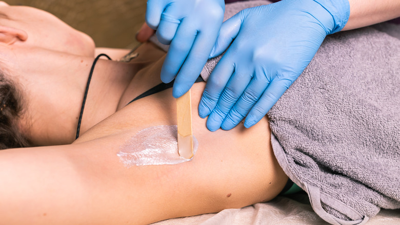 Person in salon gets underarms waxed