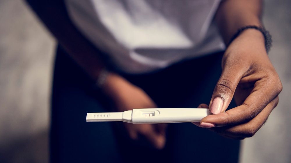 woman holding pregnancy test