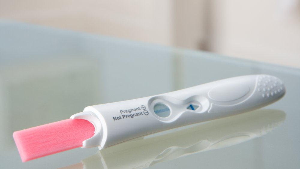 woman holding pregnancy test