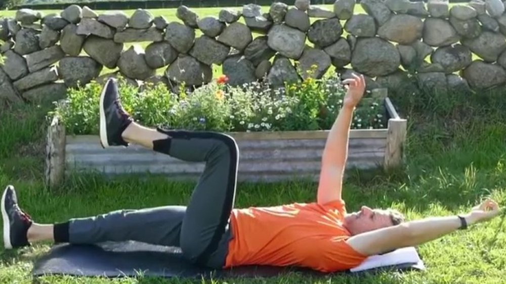 A man stretches in dead bug pose