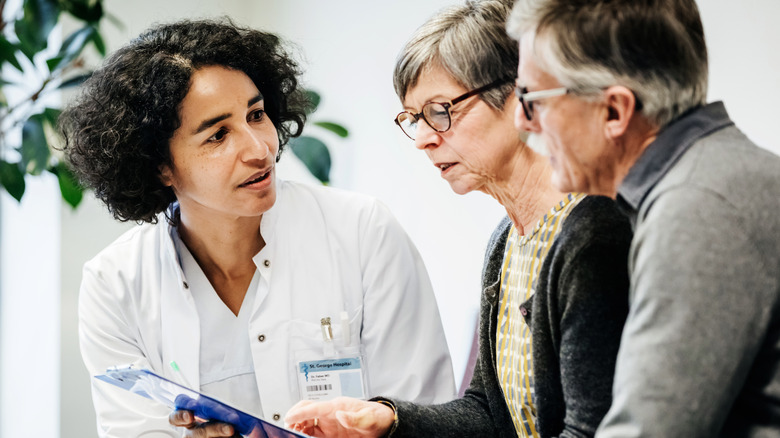 doctor talking with older couple