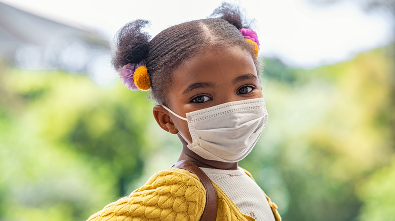 Child wearing mask and backpack